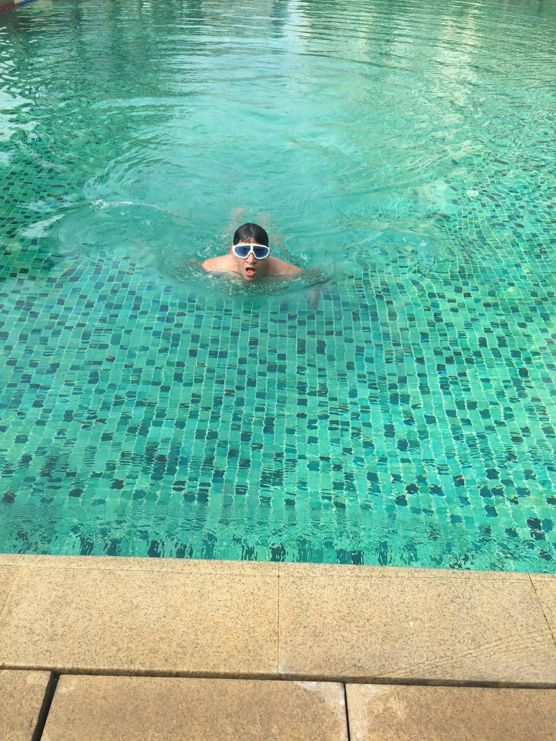 Kunwer Sachdev swimming laps with goggles in a pool