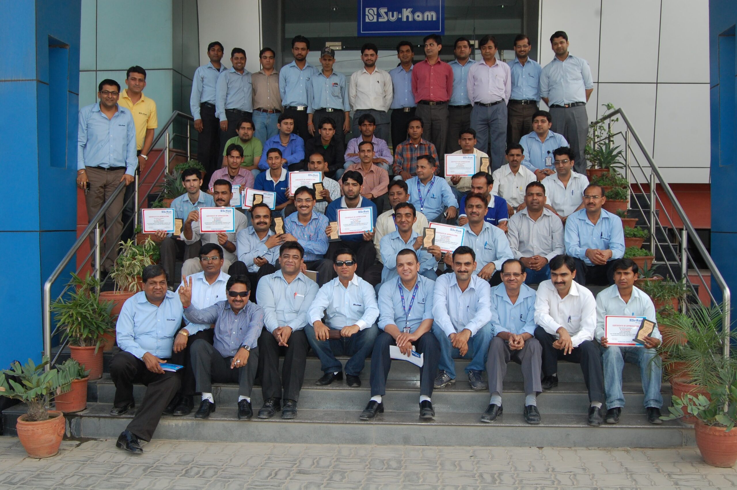 Su-Kam team with certificates at office