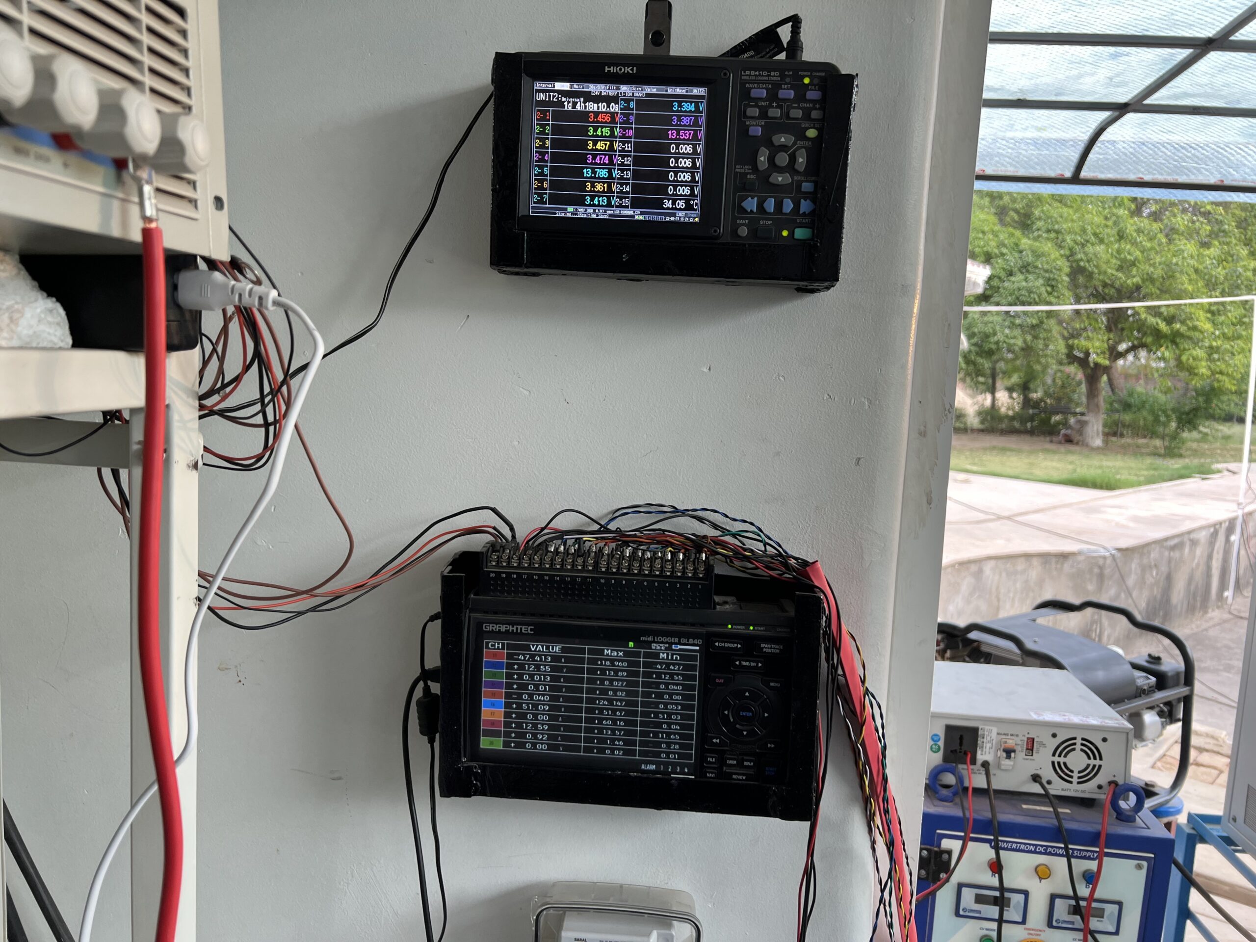 BMS testing rig with Hioki wireless logger and Graphtec midi LOGGER displaying cell voltages and temperature