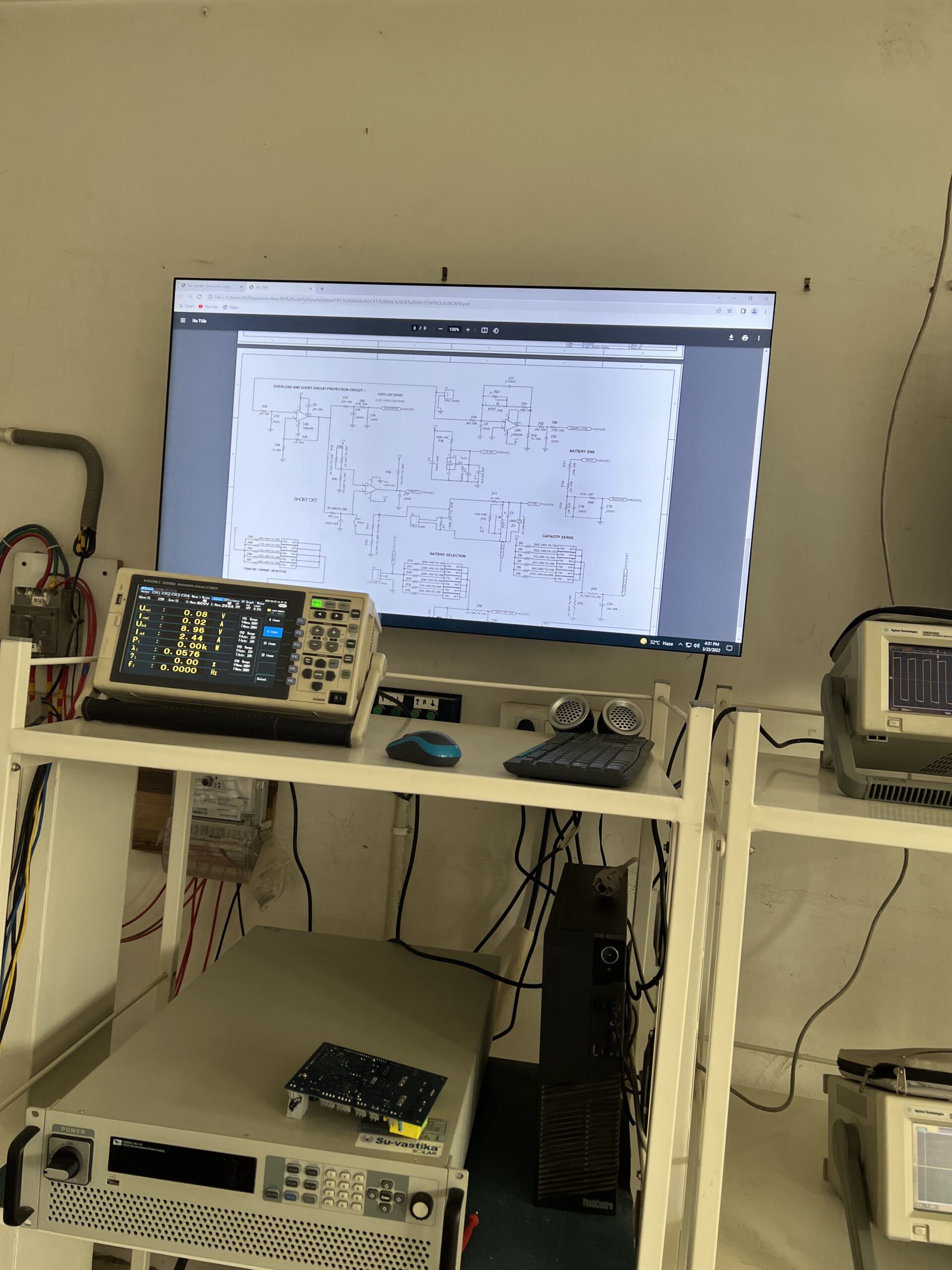Circuit board on test bench with Kikusui power analyzer and overload protection schematic on monitor