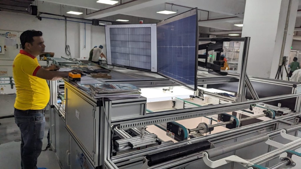 Operator at electroluminescence solar panel test station in an Indian assembly plant