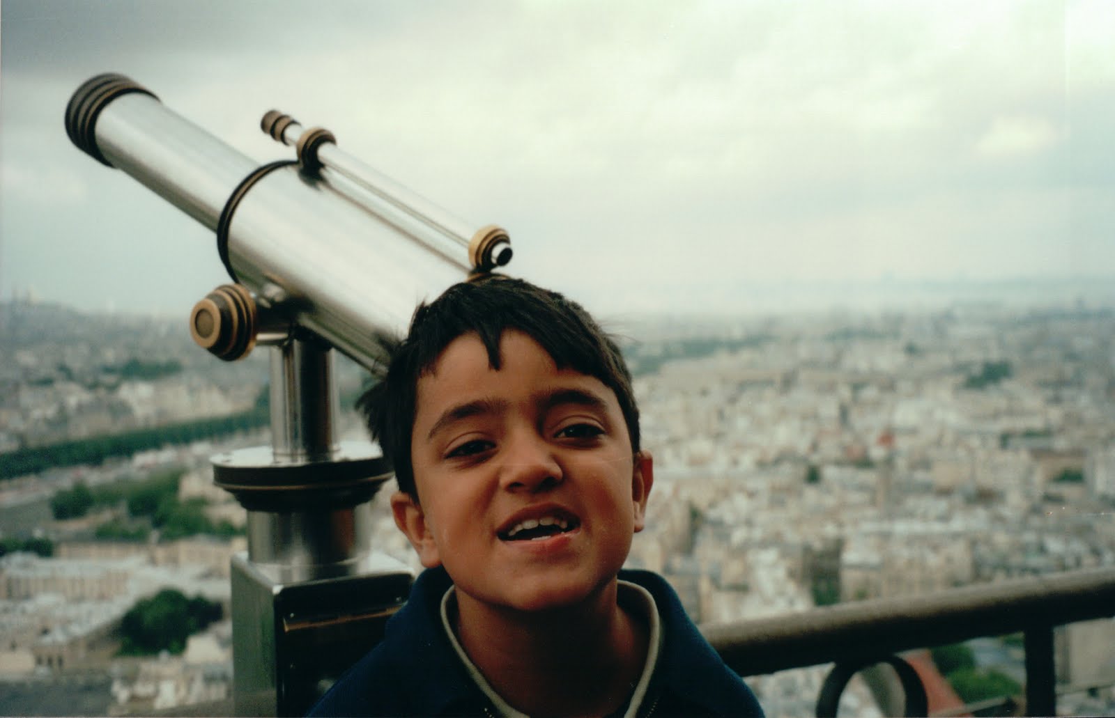 Young Shourrya at a city overlook with a viewing telescope
